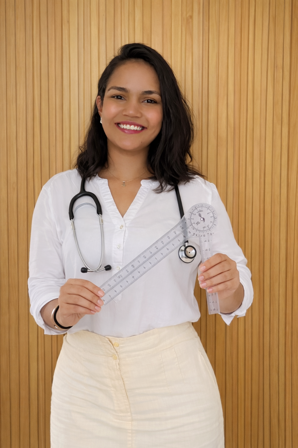 Tainara sorrindo com estetoscópio no pescoço e goniômetro nas mãos
